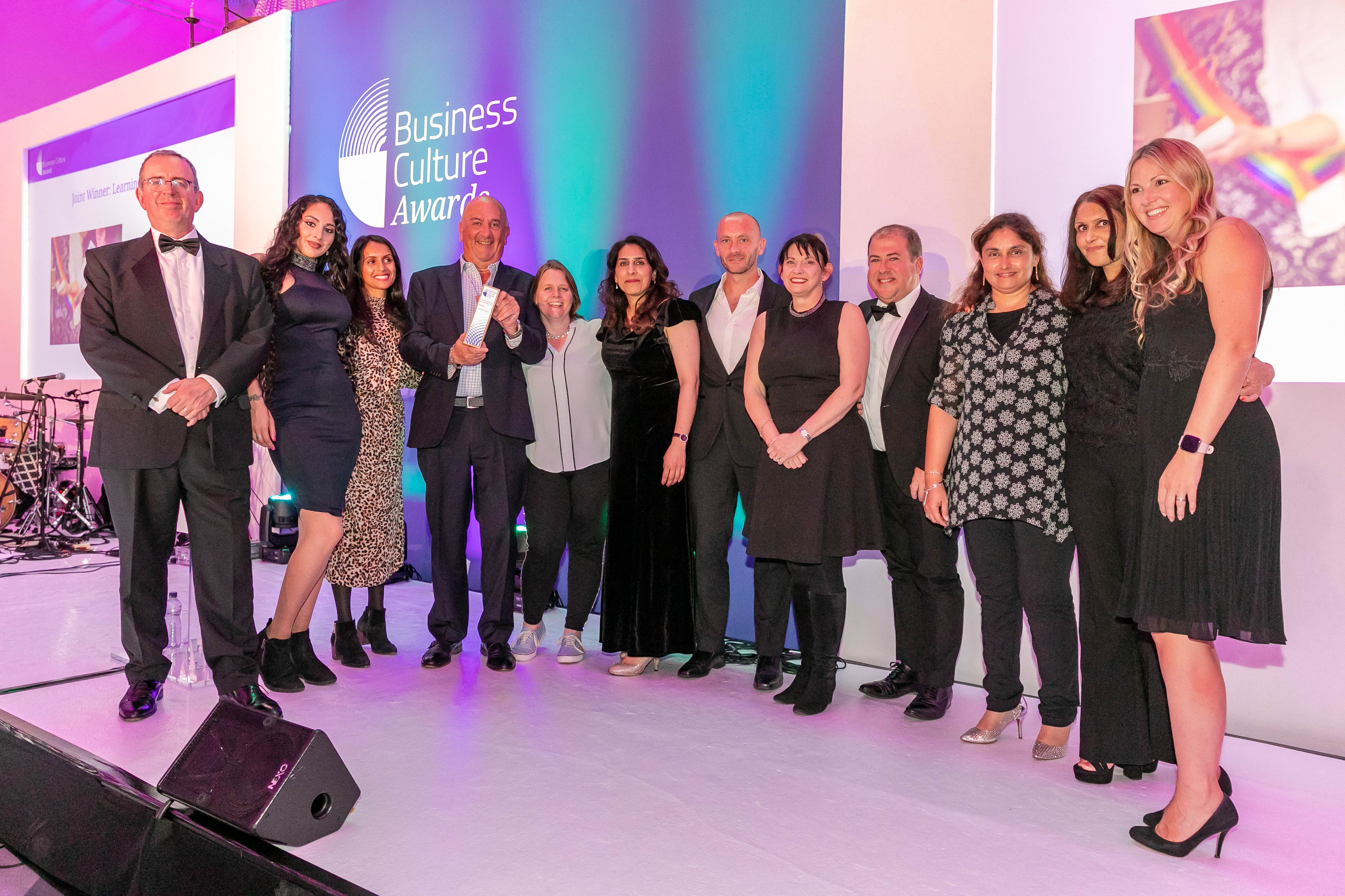 Staff grouped together collecting Business Culture Award 
