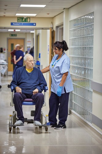 Staff member and a patient talking in a corridor