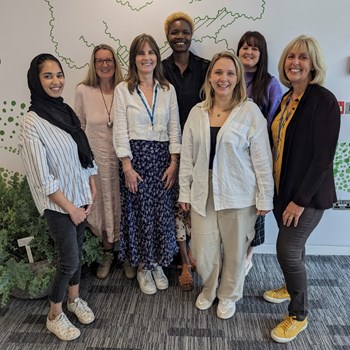 Group of seven NHS employment advisors standing together and smiling