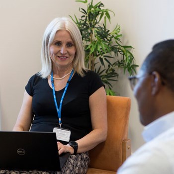 A staff member talking to a patient about feedback