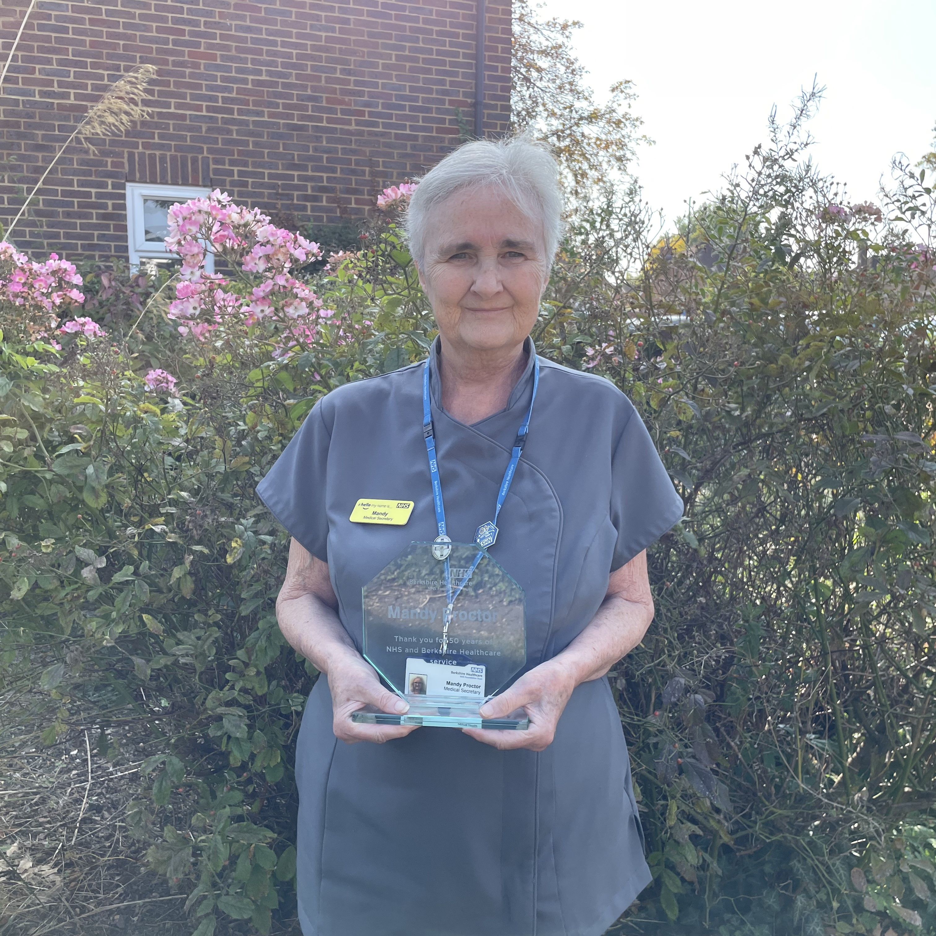 Mandy Proctor holding an award for 50 years of long NHS service