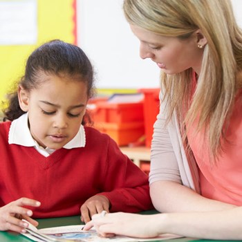 Image of teacher helping child with schoolwork