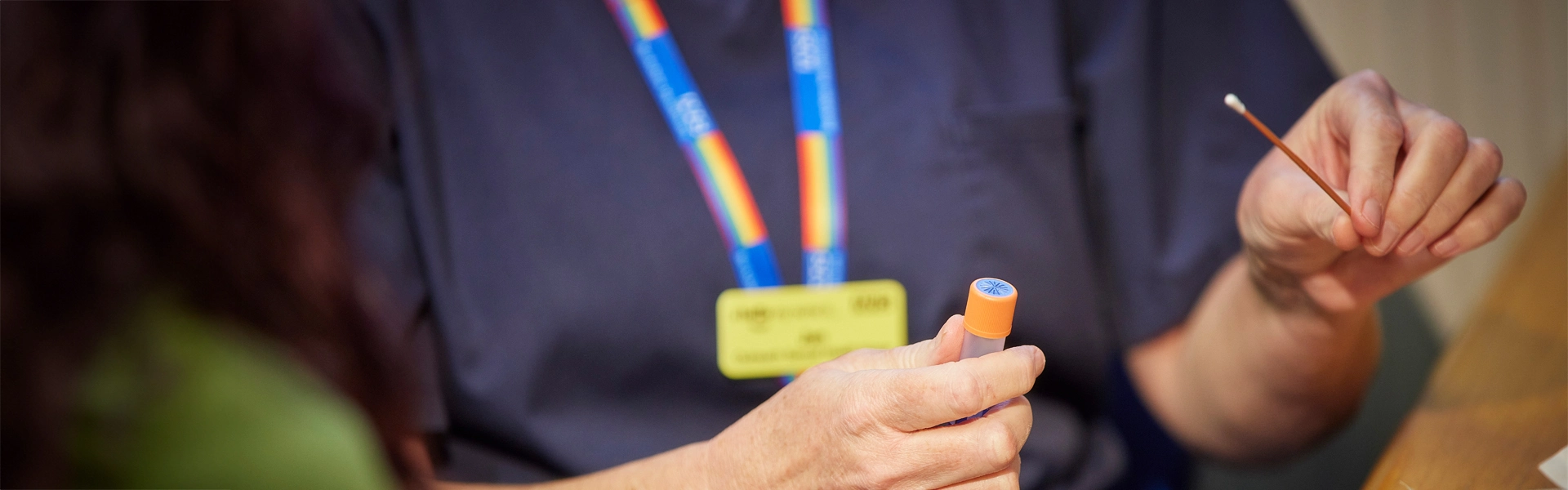 clinician showing a patient how to use a swab