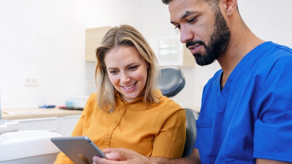Staff member and patient looking at tablet device