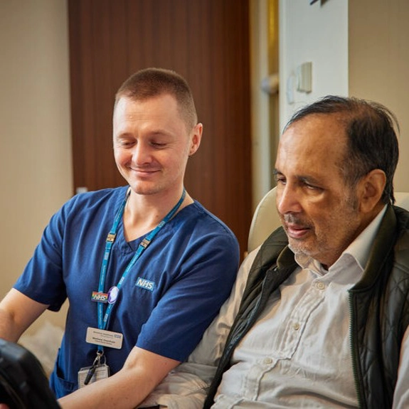 Staff Member And Patient Looking At Tablet Cropped